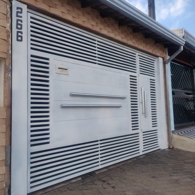 Portão automático cinza com lâminas horizontais e detalhe branco