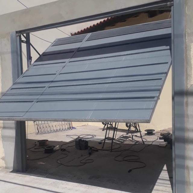 Portão basculante cinza aberto em garagem